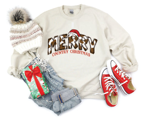 Merry Country Christmas crewneck with brown cow spots in the "Merry" text, perfect for adding a rustic, country-inspired touch to holiday attire.
