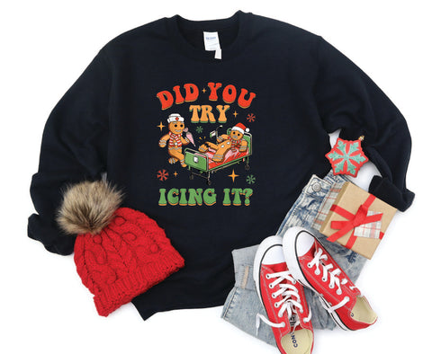 Did You Try Icing It?" holiday crewneck featuring a gingerbread man in a hospital scene with a gingerbread nurse, adding humor and festive cheer to a cozy winter sweater.