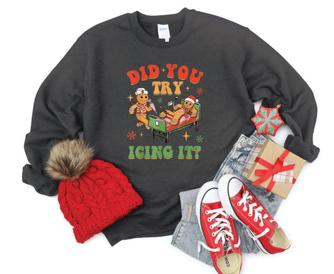 Did You Try Icing It?" holiday crewneck featuring a gingerbread man in a hospital scene with a gingerbread nurse, adding humor and festive cheer to a cozy winter sweater.