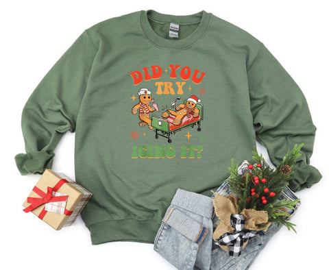Did You Try Icing It?" holiday crewneck featuring a gingerbread man in a hospital scene with a gingerbread nurse, adding humor and festive cheer to a cozy winter sweater.