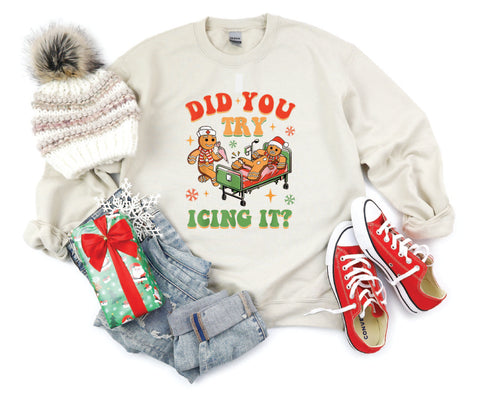 Did You Try Icing It?" holiday crewneck featuring a gingerbread man in a hospital scene with a gingerbread nurse, adding humor and festive cheer to a cozy winter sweater.