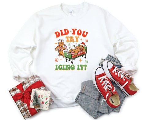 Did You Try Icing It?" holiday crewneck featuring a gingerbread man in a hospital scene with a gingerbread nurse, adding humor and festive cheer to a cozy winter sweater.